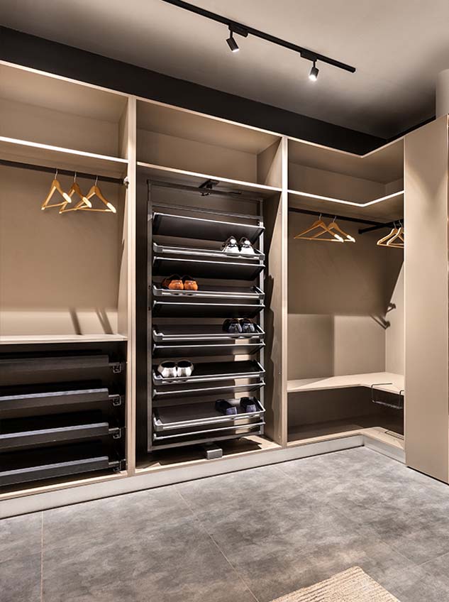 Walk in wardrobe 3 Open wardrobe with pull-out shoe racks, drawers, and hanging space.