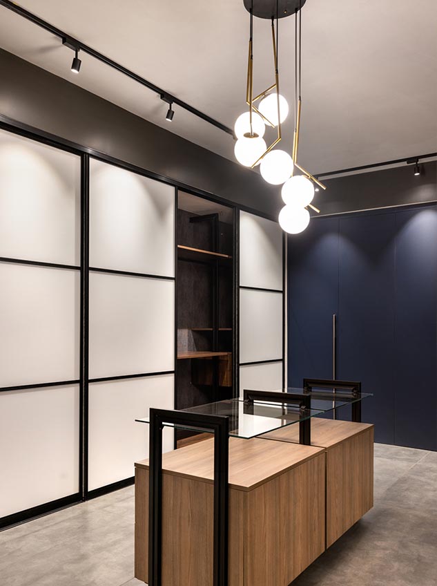 Sliding wardrobe 1 Modern wardrobe showroom with glass island and panelled walls.