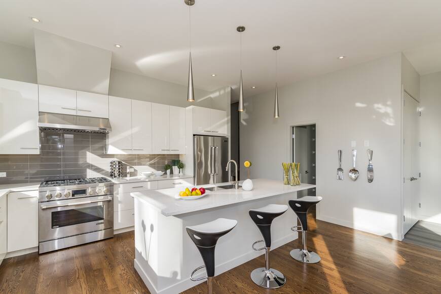 Sleek alea modular kitchen design with white cabinets and stainless steel appliances, highlighting modern functionality and style.