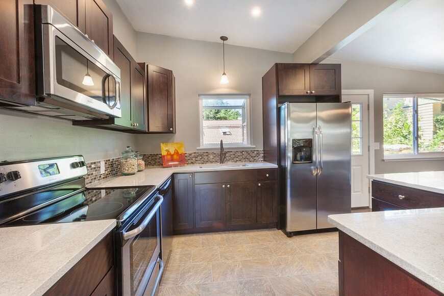 A modern alea modular kitchen featuring stainless steel appliances and elegant wood cabinets.